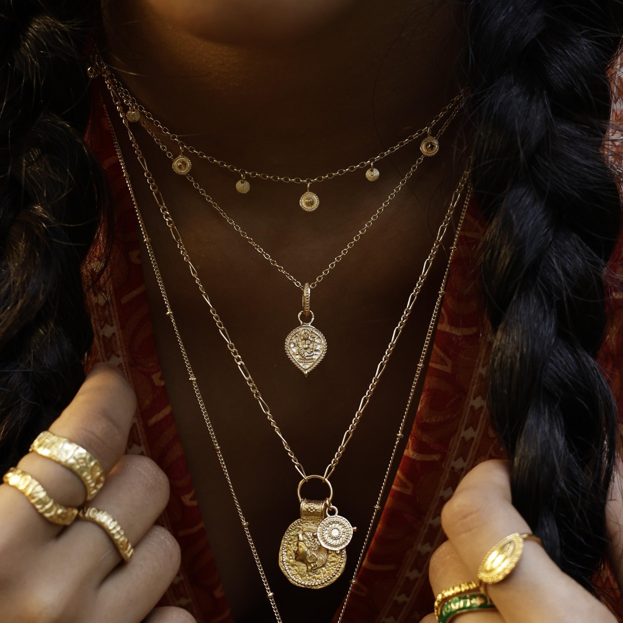 Model wearing You Got This Shield Pendant layered with other Loft & Daughter talismans