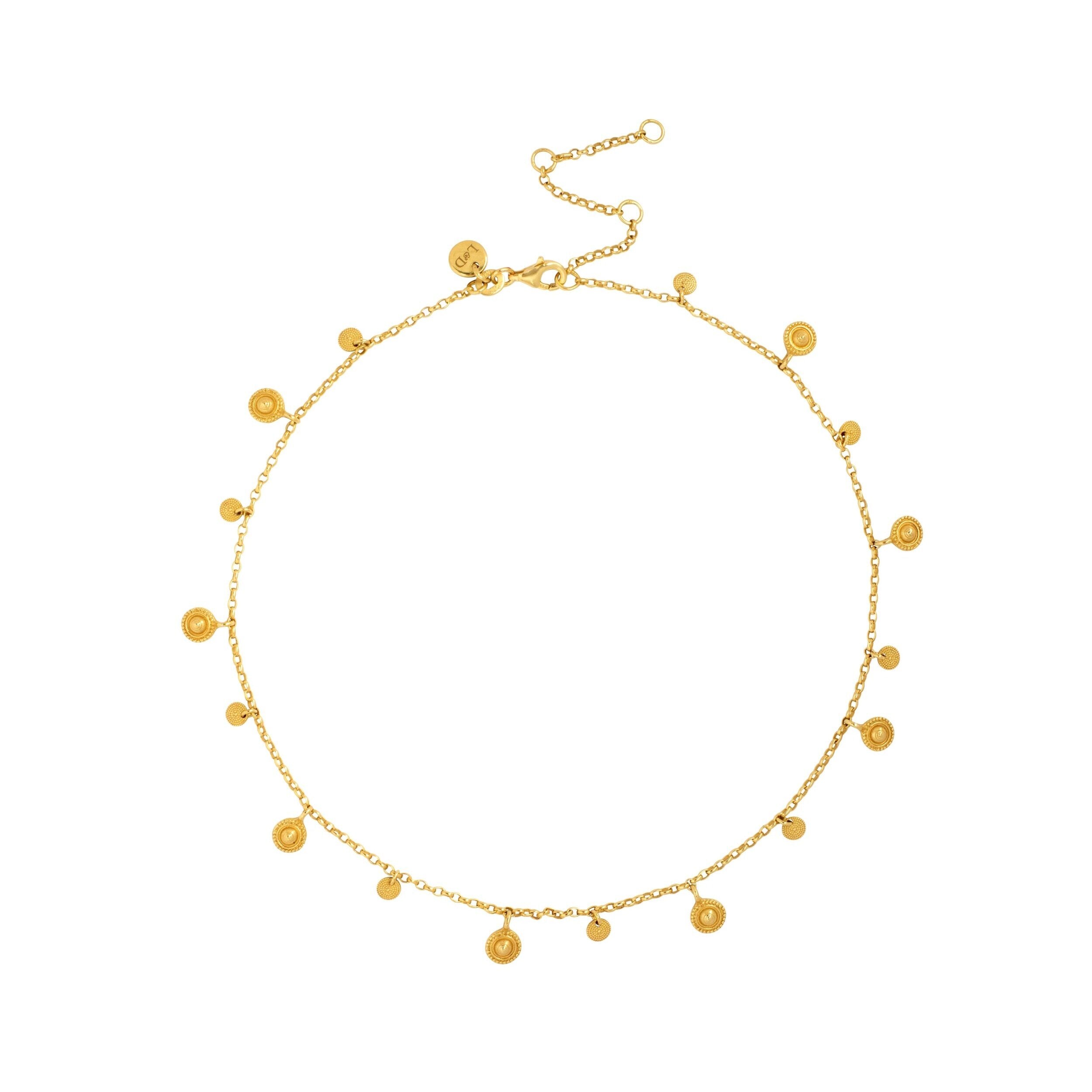 A gold-toned choker necklace featuring multiple small coin-shaped pendants alternating in size and design, displayed against a white background.