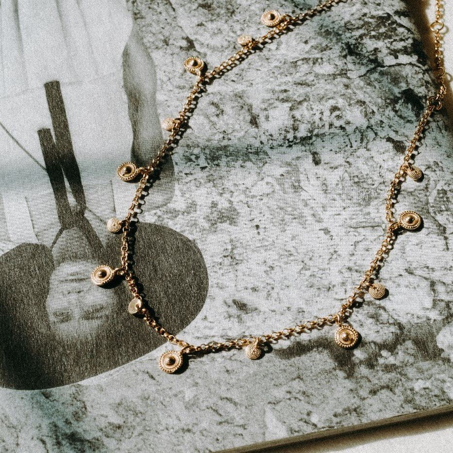 Mini gold coin choker on open book page